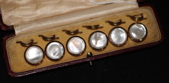 A cased set of six gilt metal mounted mother of pearl dress studs.